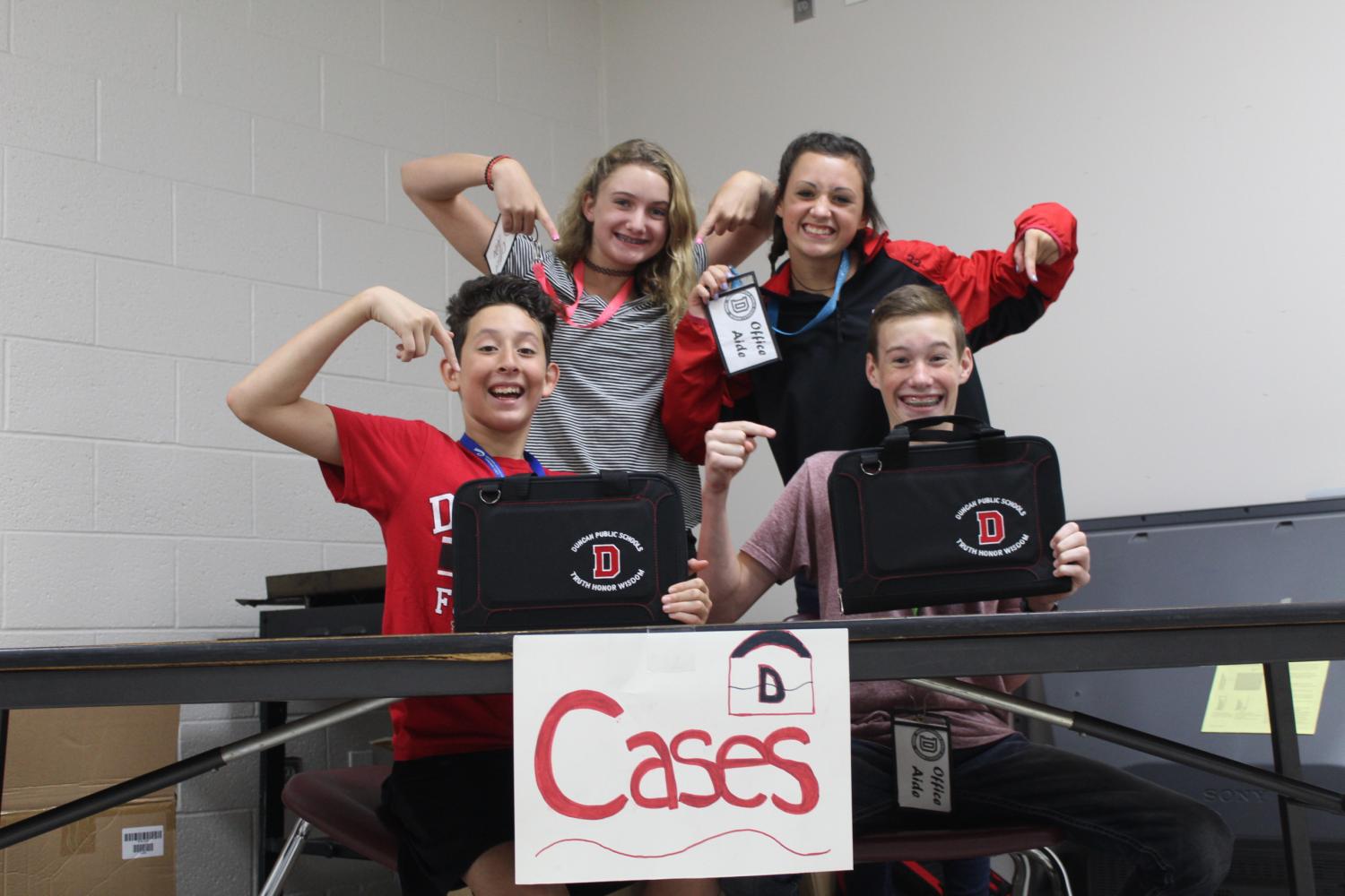 Devan Reyes, Ava Curry, Carsyn Etheridge and Micah Miller prepare to pass out Chromebooks to DMS eighth-grade students.