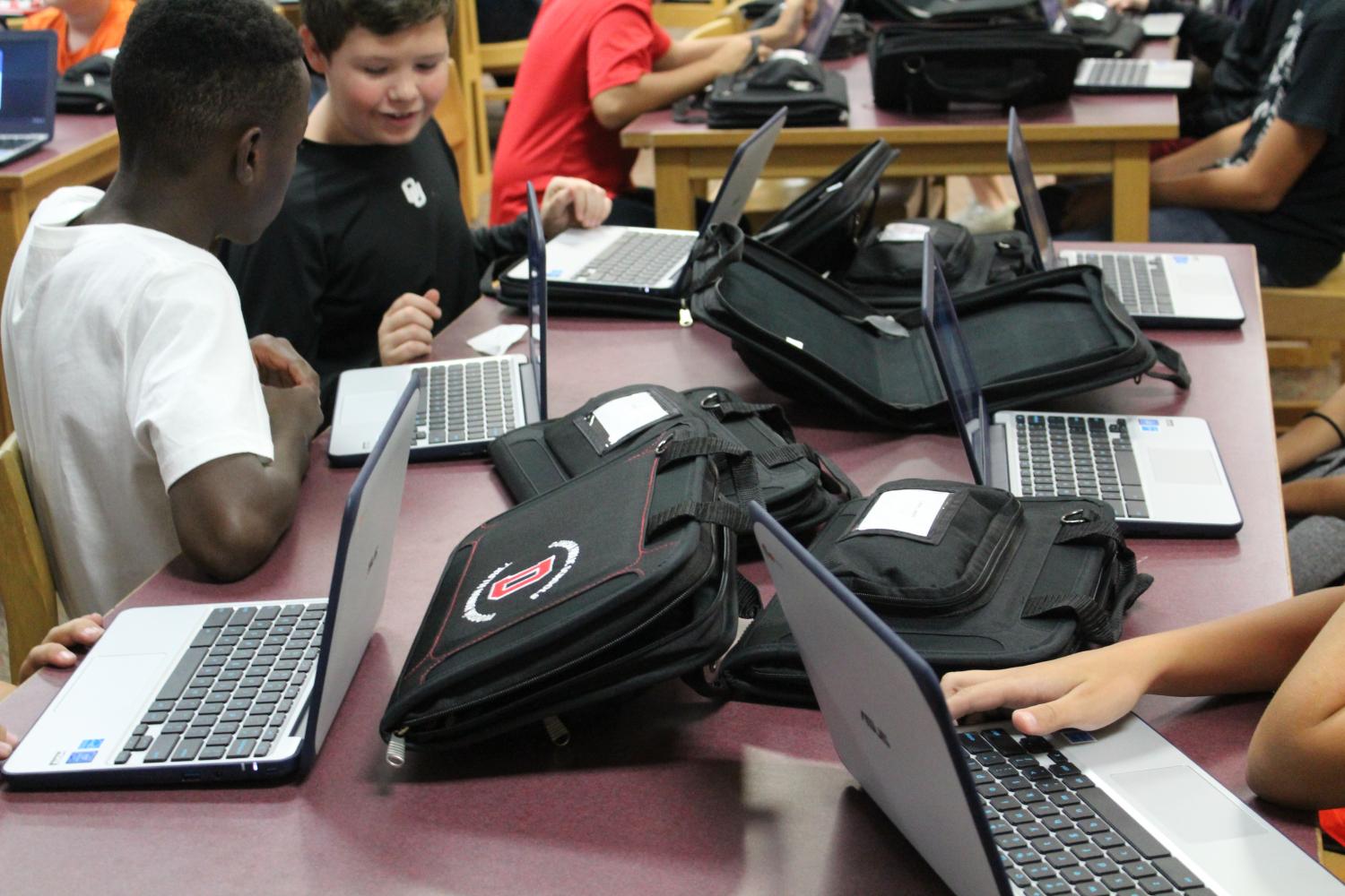 Sixth-grade students receive their Chromebooks Friday during Duncan Middle Schools device roll out.