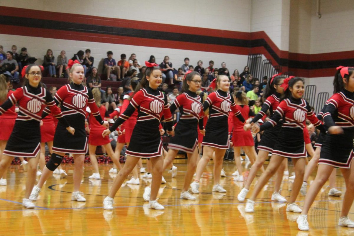 DMS cheerleaders dance in front of the student body.