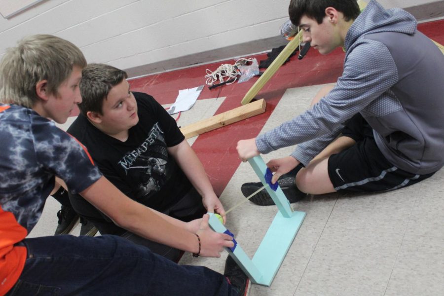 Trey Guernsey, Caleb Frost and Gavin Lindsey build a catapult in their eighth-grade science class.