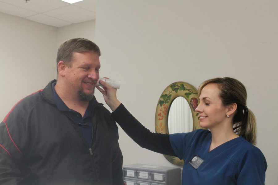 DMS Nurse Tabitha Sale takes Assistant Principal Rodney Struttons temperature.