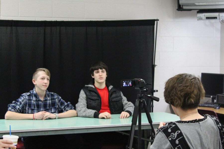 Acacia Luke films Trey Guernsey and Johnathan McRae providing the sports update.