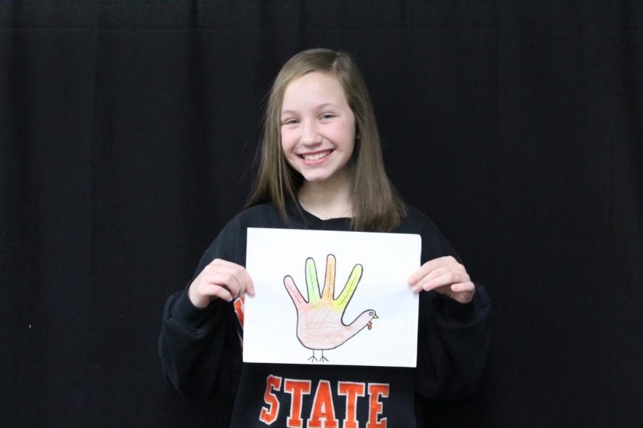 Allison Bailey, seventh-grader, shows off the turkey hand tracing she did for Thanksgiving.