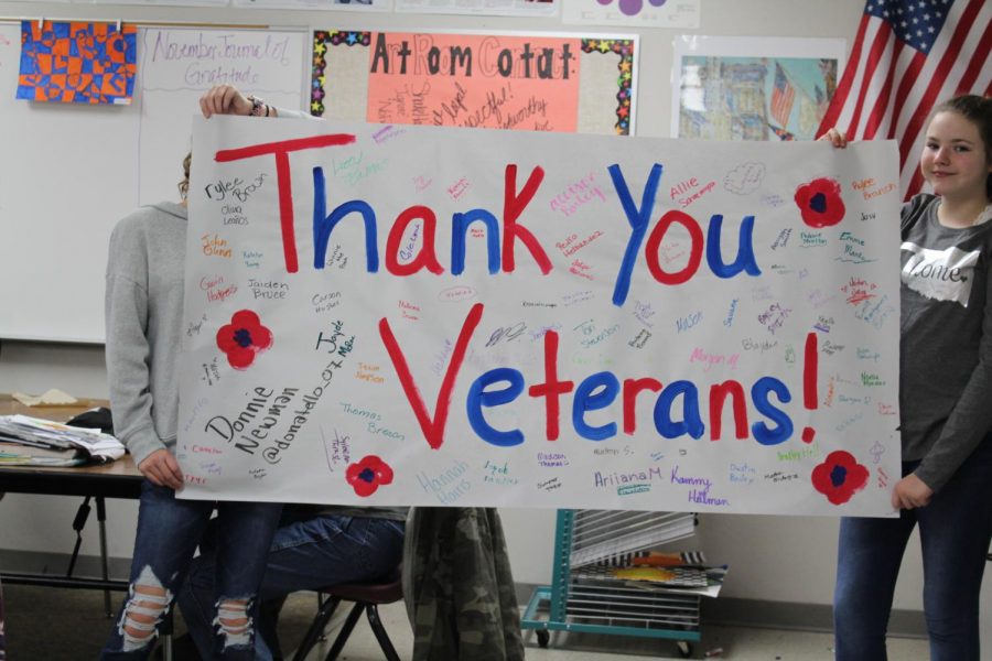 Art students show off the banner created for Veterans Day.