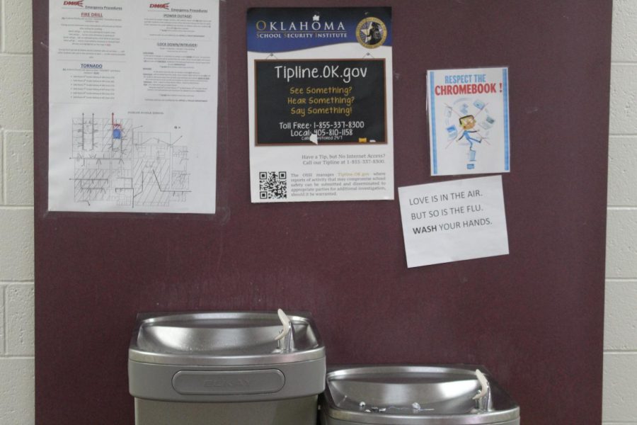 A sign above the water fountains in the eighth-grade hall remind students about the flu.