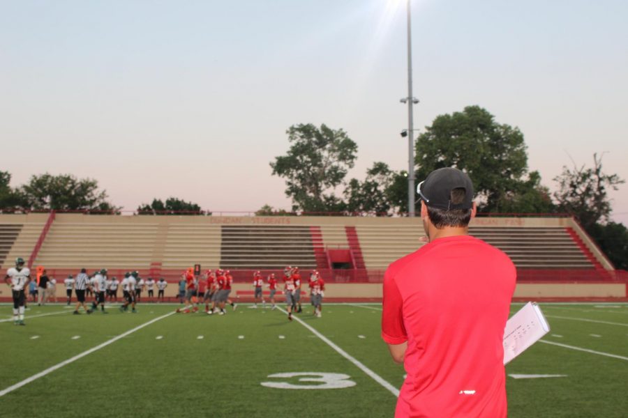 Coach Drew Wortham watches from the sidelines during the first game of the football season.