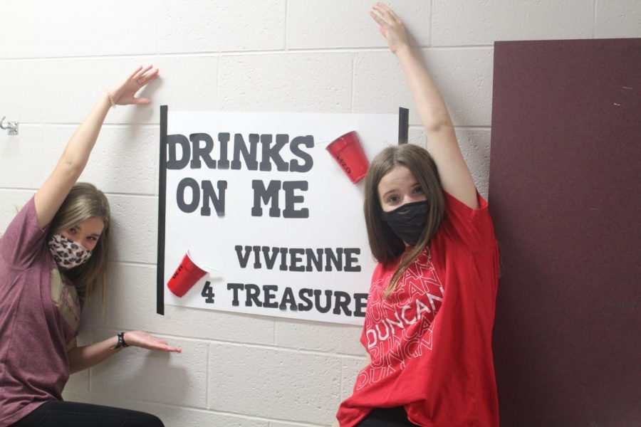 Vivienne Albin shows off her campaign poster at the end of the seventh-grade hall.