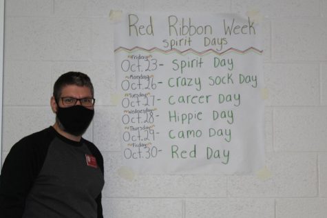 Derrick Miller, one of the NJHS sponsors at Duncan Middle School, shows off a poster of the dress-up days.