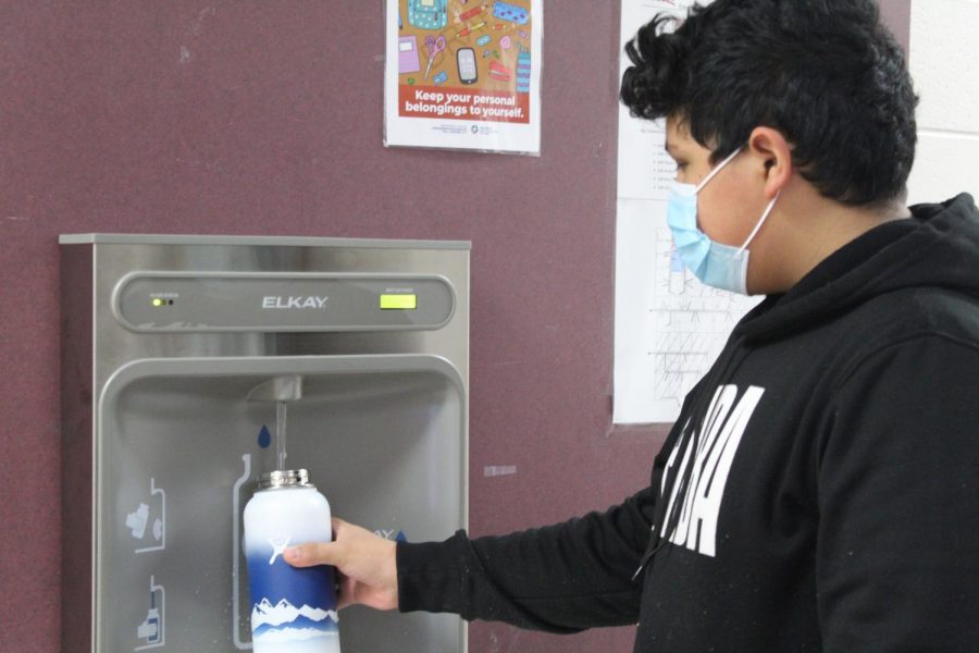 Armando Garcia-Diaz fills a water bottle using the new filter water station in the seventh-grade hall.