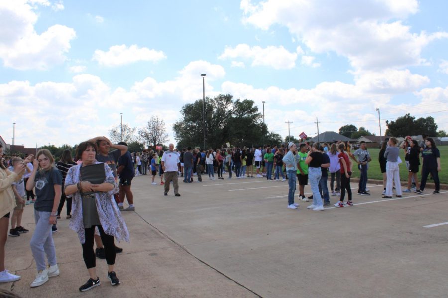 Students and teachers gather in a parking lot across the street from Duncan Middle School, during an evacuation drill.