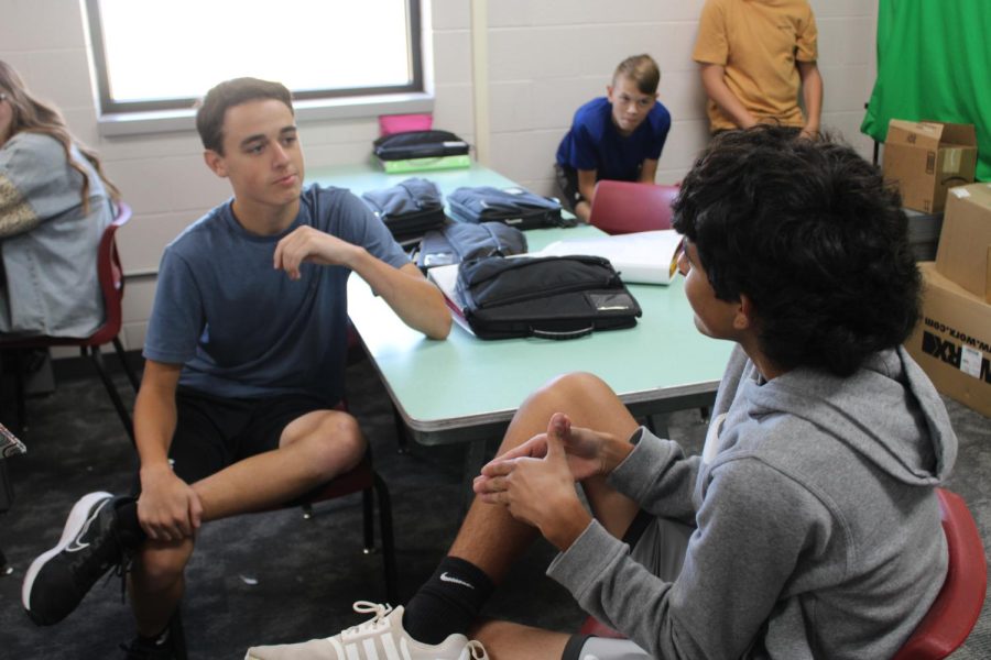 Devan Johnson, an editor for yearbook, talks with Eric Hernandez about the Academics section of the yearbook.