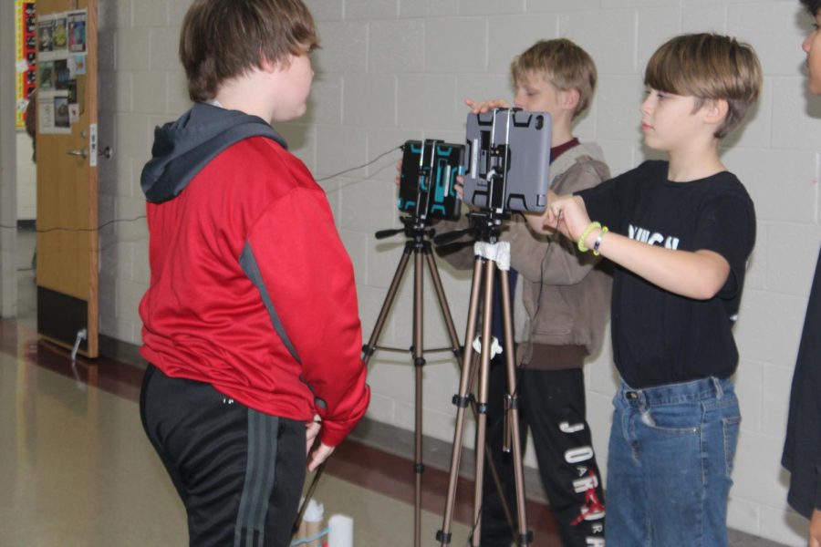 Sixth-grade STEM students record as part of a STEM project.