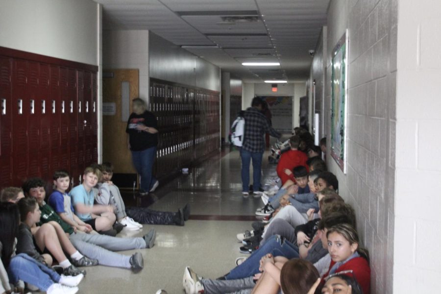 Duncan Middle School students sit in the hallway during the power outage this morning.