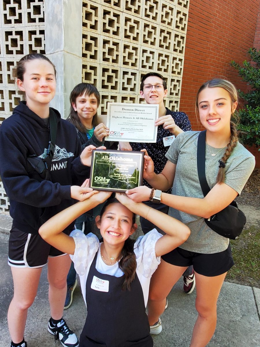 Members of the Demon Direct staff, including Ava Allbritton, Easten Hutto, Bella Reyes, Davis Wheeler and Berkley Morris, show off the plaque the Demon Direct received for OSM Critical Service.