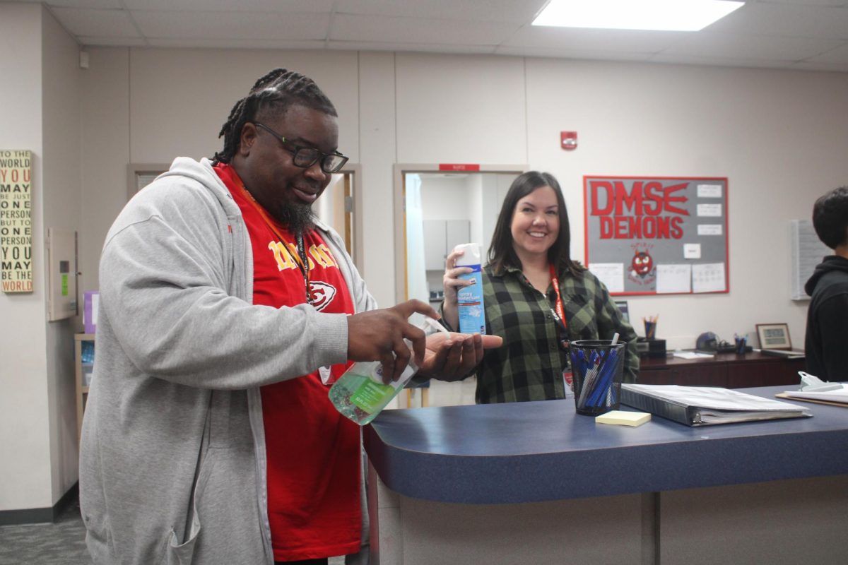 Counselor Isacc Mason uses hand sanitizer in the office. Absences have been on the rise at DMS.