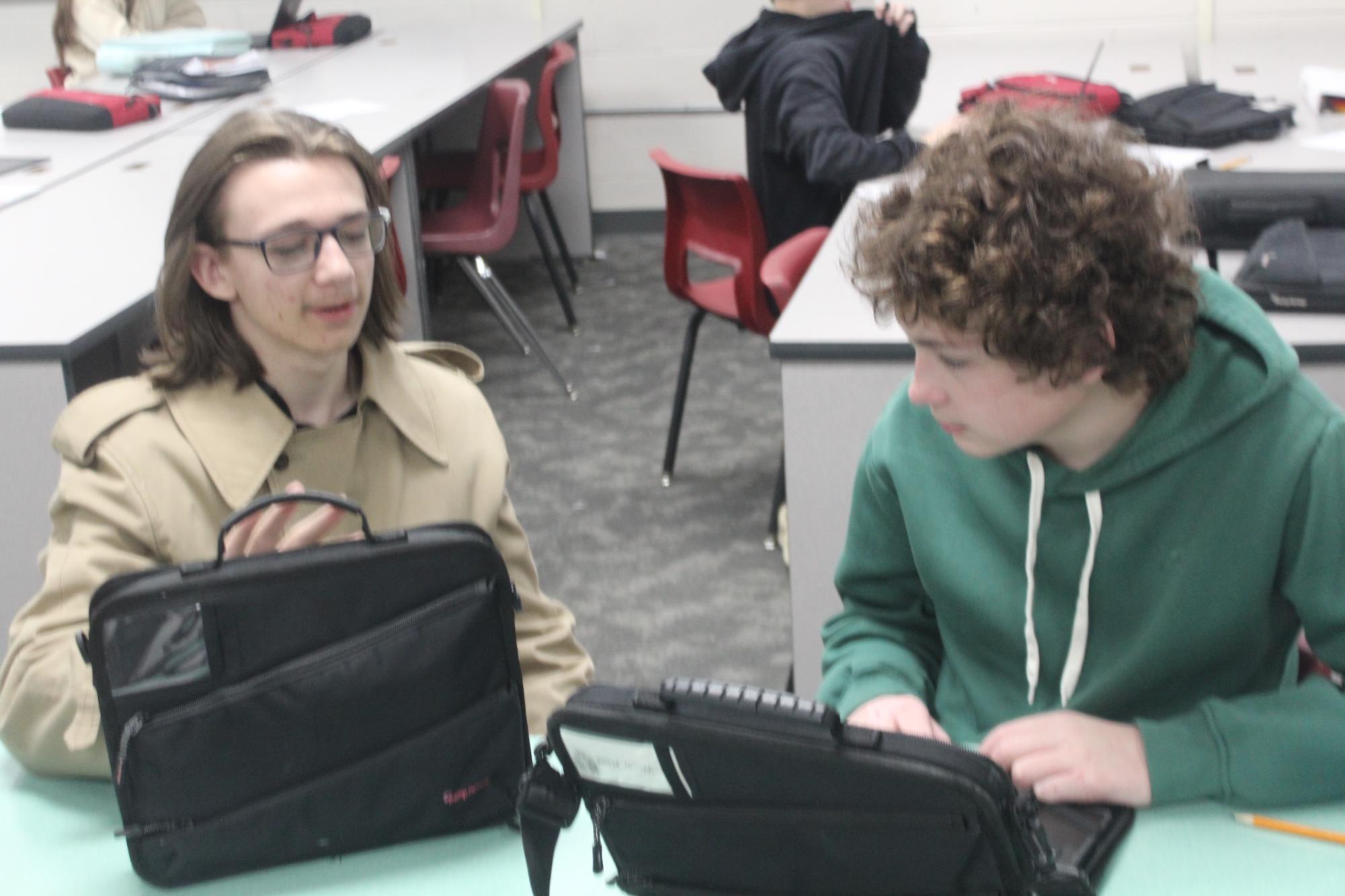 Thor Beck, left, works with Reid Webb, as they discuss an article. Beck is now an editor in chief.