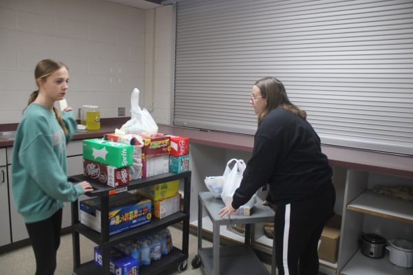 Ady Cooks helps financial clerk Brittany Edwards stock concession items for tonight's dance.