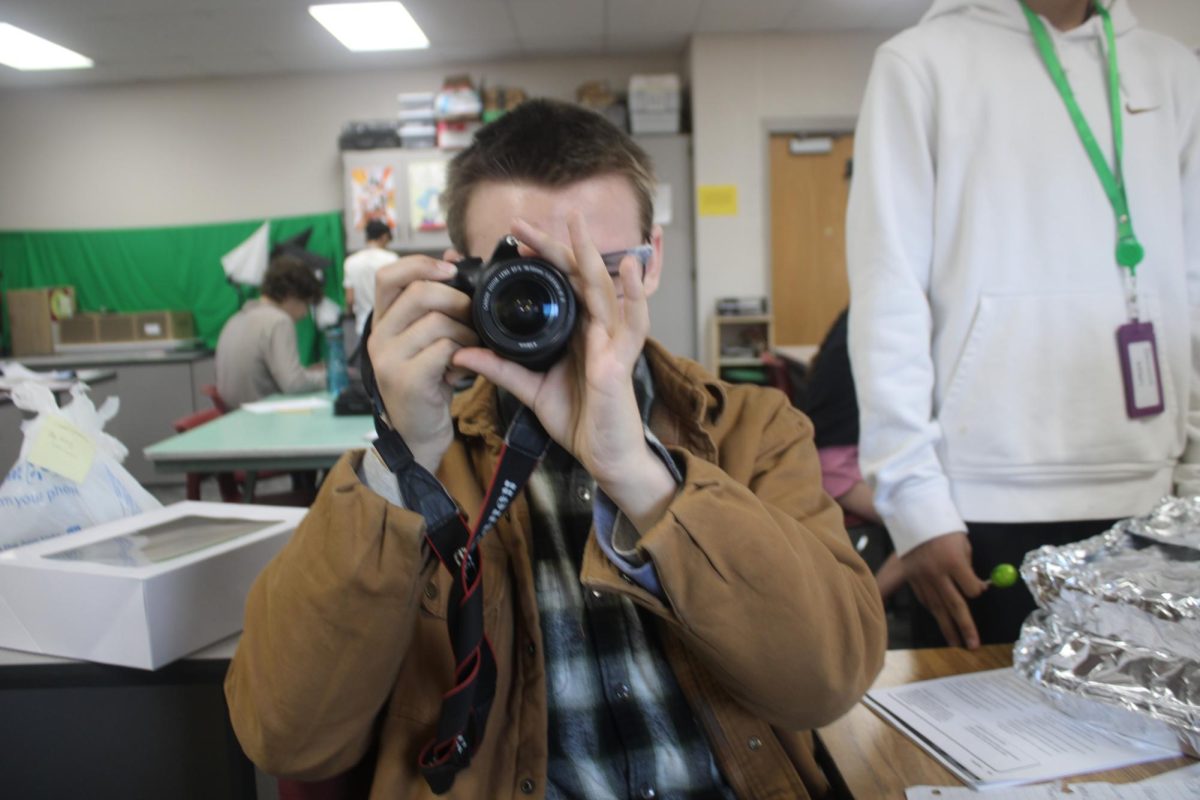 Editor in chief Thor Beck practices taking a photo during class.