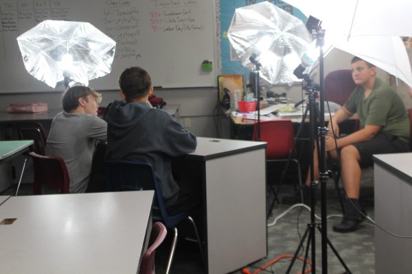 Matthew Hopson and Jaxon Millan prepare for their video, while Case Howell looks on.