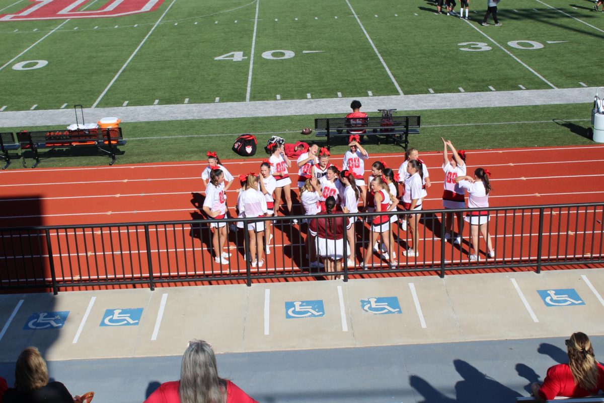 Cheerleaders gather toward the start of the seventh-grade football game on Tuesday.