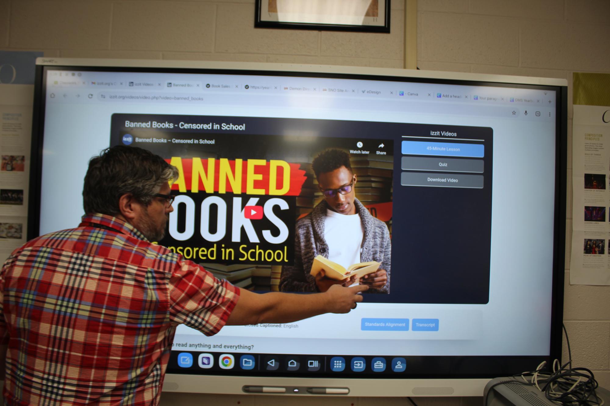 DMS journalism teacher Derrick Miller goes to play a video for Banned Books Week.