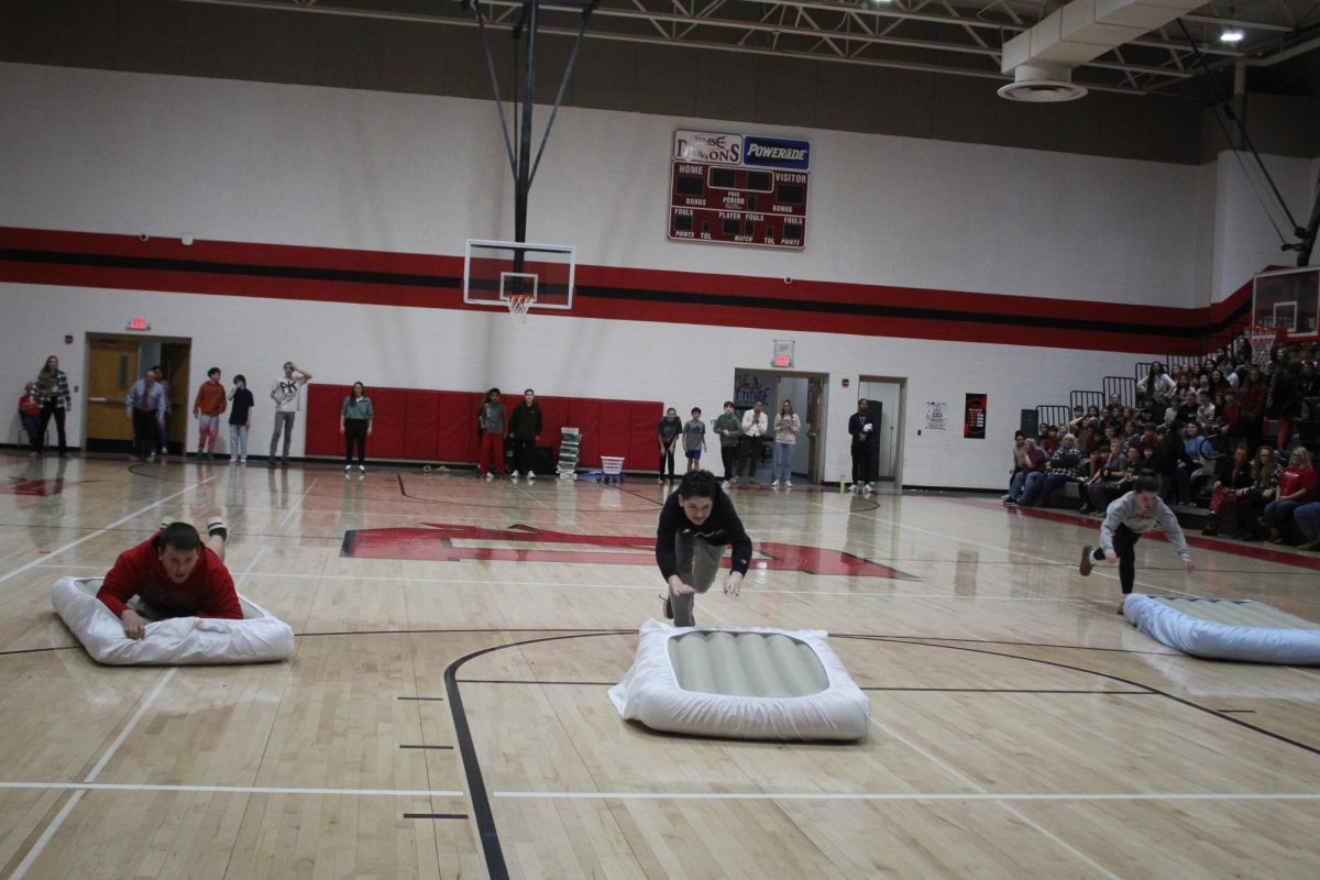 Students jump and slide on mattresses in hopes of winning for their grade levels.
