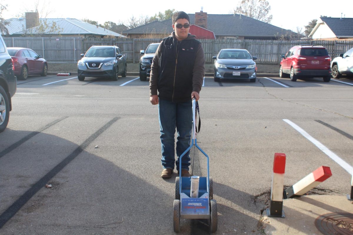 Cason Baker uses the line drawing tool in the DMS south parking lot as part of his life management class.