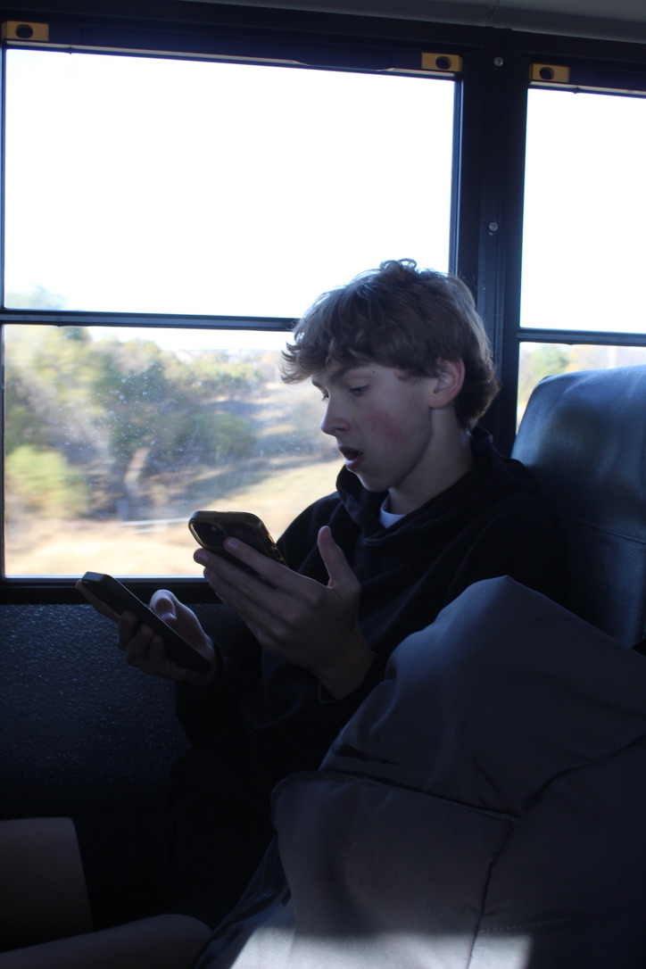 Zack Ottwell uses his cell phone on a school bus. Students are not allowed to use their cell phones in school buildings in Oklahoma.