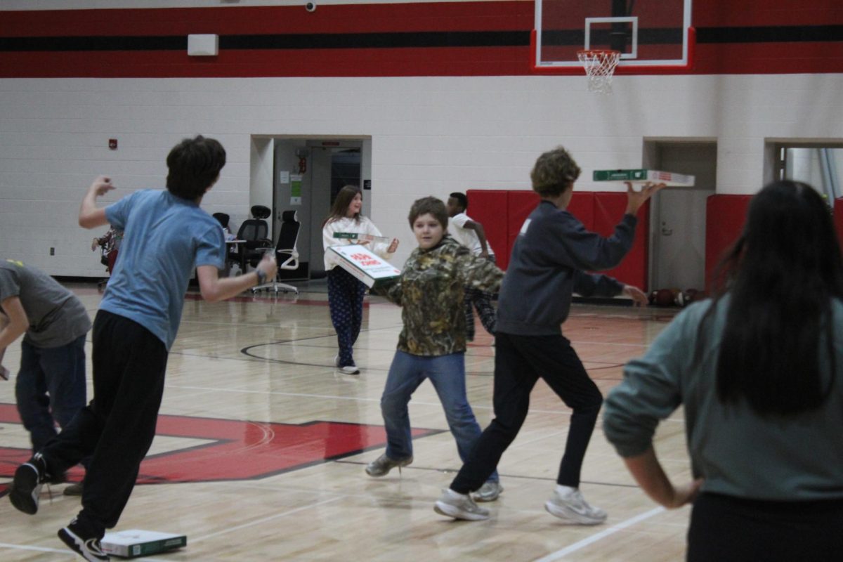 Students work to topple each other's pizza boxes.