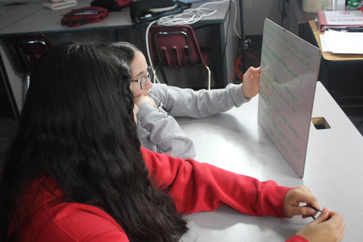 Carleigh Nalley and Yoselin Ontiveros look over the script for the News Update.
