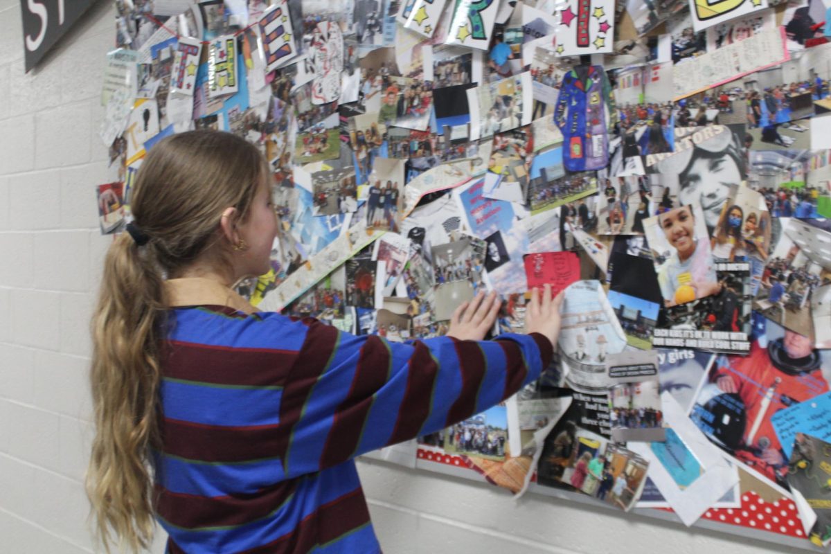 Georgia Jeffrey works on a bulletin board outside the STEM classroom. Jeffrey was one of several students selected for a leadership training.