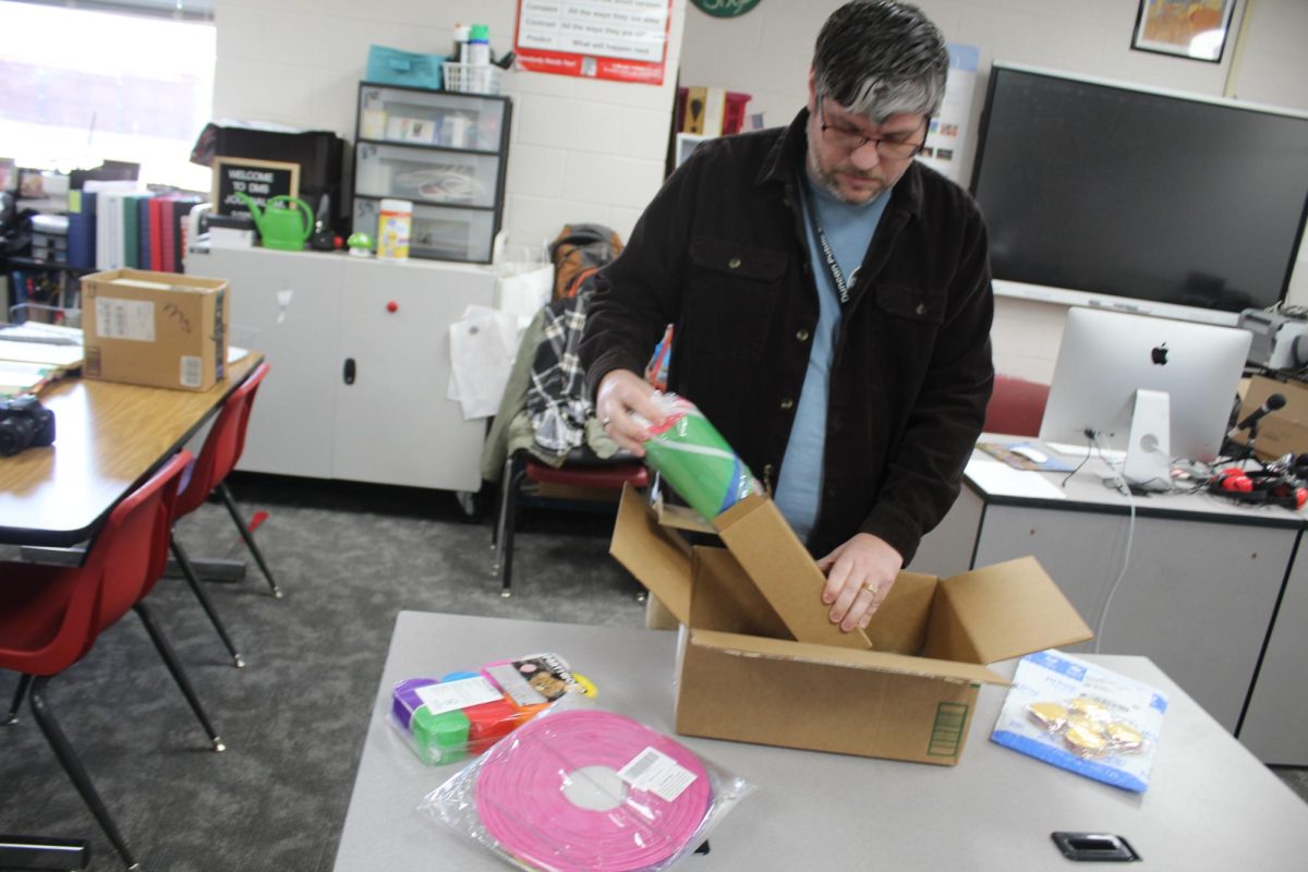 Derrick Miller looks through dance decorations. The school dance is set for Friday night.