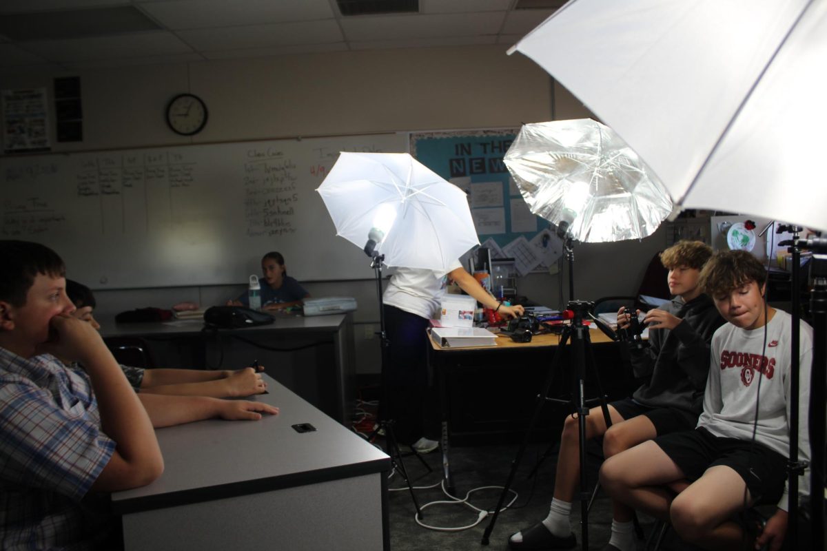 Cash McRoy prepares to film, while Case Howell and Gabriel Hernandez study the script.